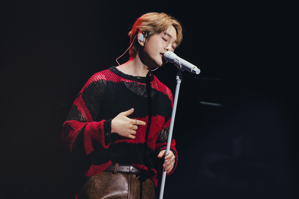 Onew onstage performing Mad