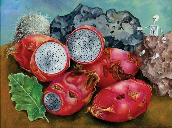 bright red egg shaped dragonfruit, some cut in half, are arrayed in front of two gnarled, pitted rocks, one black-grey, the other brown.  There is another fruit or seed of some kind that is brown and covered with fine white hair (I don't know what it is), and a bright green leaf.  There is a small skeleton with a long sickle sitting on one of the rocks.
