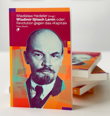 Auf dem Tisch liegen und stehen mehrere Exemplare unserer Biografischen Miniatur zu Lenin: »Wladimir Iljitsch Lenin oder: Revolution gegen das ›Kapital‹«, herausgegeben von Wladislaw Hedeler