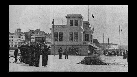 Persoas co brazo en alto como saudo nazi ante unha pira de libros, na zona do porto da Coruña. En branco e negro.
