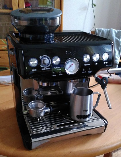 Es ist eine schwarze Siebträgermaschine mit Mühle (Sage Barista Express)