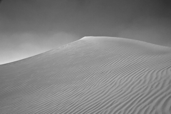 A gritty looking sand dune in black and white
