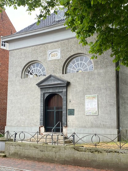 Kirche in Leer mit Fensterfront und Tür, die mich an ein Gesicht erinnern