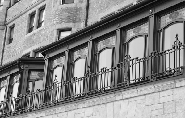 Black and white close up photo of a row of windows in a brick and stone wall, protected by a decorative metal railing.

This is Château Frontenac in Quebec City. The photo was taken on Terrasse Dufferin. Inside these windows is a restaurant.