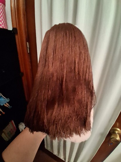 El cabello de la muñeca por atrás. Lo tiene largo hasta la cintura con un corte recto