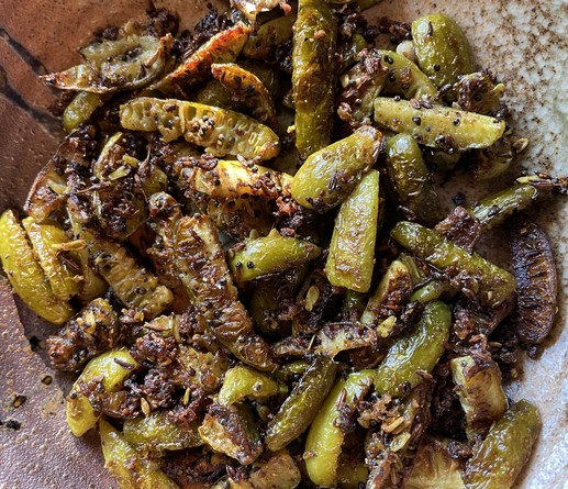 Tindora dry curry on a pottery plate.