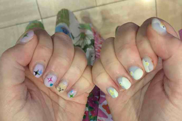 Manicure showing four-pointed stars and PuppyM on one hand, and duckies on the other hand.