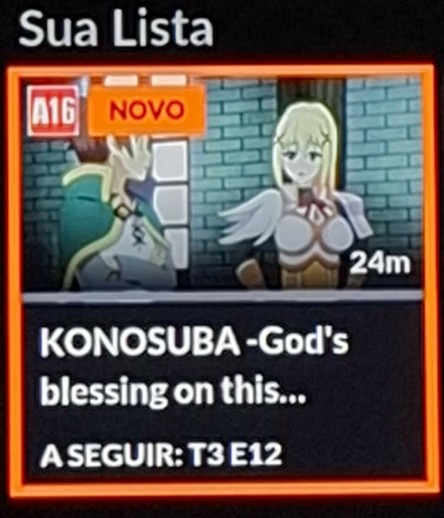 A imagem mostra a imagem referente ao anime "Konosuba" em foco na lista do Crunchyroll. Vemos uma mulher loira de seios fartos e um rapaz, ambos com roupas que parecem sugerir algum tipo de fantasia medieval. Percebemos também o símbolo A16 (censura de 16 anos) e, principalmente, o símbolo NOVO indicando que há novos episódios ainda não assistidos para o anime.