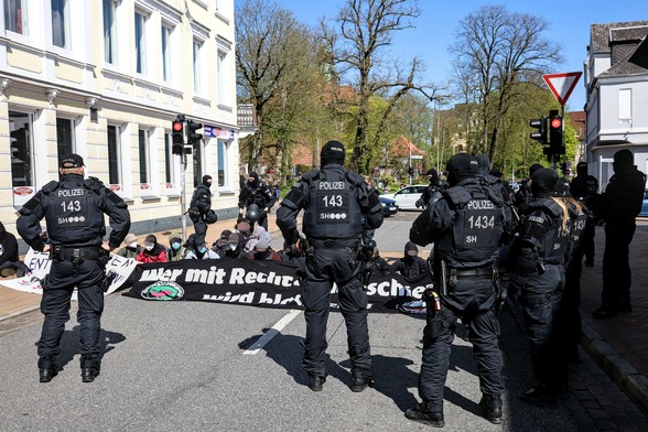Mehrere Polizist:innen stehen um eine Sitzblockade