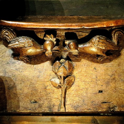 Woodcarving of fighting roosters.