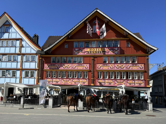 vor dem traditionellen hotel am appenzeller landsgemeindeplatz stehen gesattelte pferde