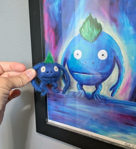 The Nu, held next to a framed print of a Nu painting. The felted Nu is like 2-3" tall