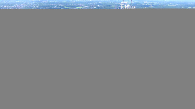 An aerial photo of Gelsenkirchen Buer. You can see some active industry in the background. There are many trees near the living and working quaters.