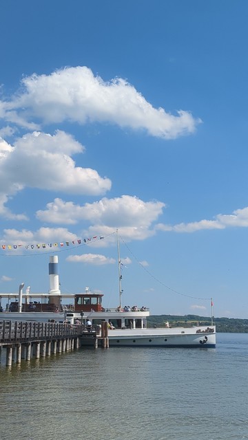 a festive boat at pier under blue sunny sky at lake Ammersee