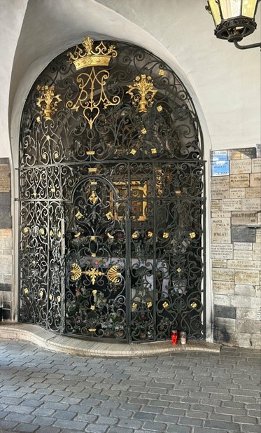 An ornate gate/doorway of black iron and and gold colored decorations.