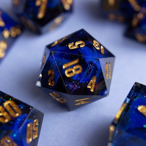 Ein D20 mit goldenen zahlen. Dahinter glitzert es und man sieht einen Farbwirbel aus Ultramarin, Schwarz und colorshifting mica.