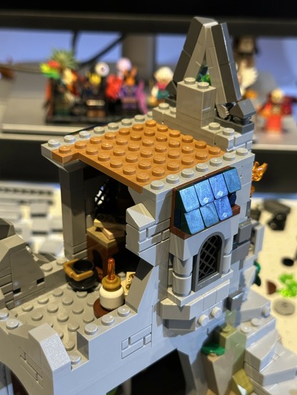 Bag 23 of LEGO set 21348. Gray stone walls and a tan wooden floor enclose the arcane workshop on the tower’s first floor.