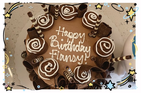 A picture of a cake reading “Happy Birthday Flansy!” across its center.