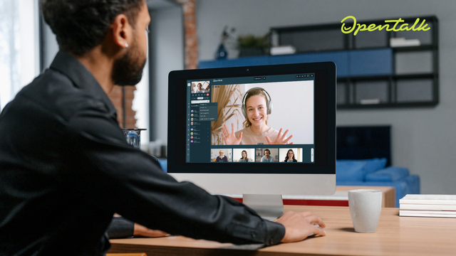 A person is sitting in front of a screen. In an OpenTalk video conference, people are divided into different groups in a list on the screen.