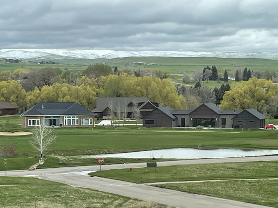 A layer of clouds concealing the tops of the local mountain range south-west of town in Sheridan Wyoming. Several homes are visible in the foreground of the photographs.