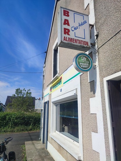 enseignes extérieures indiquant la présence d'un bar et d'une épicerie. "Chez Arlette"