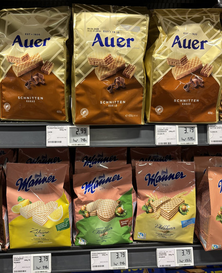 Ein Regal im Supermarkt mit verschienenen Sorten Waffelkeksen, eine Reihe ist von Auer, eine von Manner.