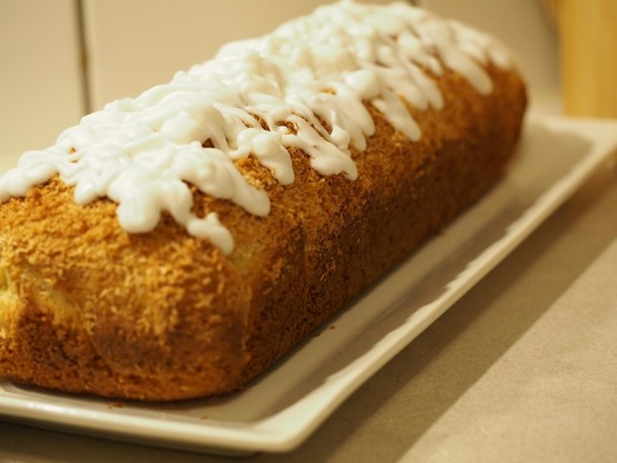 Der fertige Kuchen auf einer weißen Platte. der Kuchen wurde mit einer weißen Zitronen-Fettglasur bekleckst.