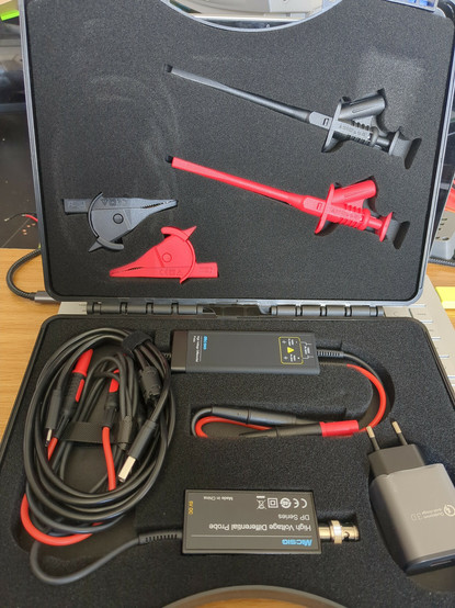 Interior of the case, showing the probe, cabling, USB-C adapter, high isolation alligator clips...