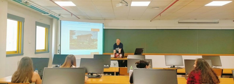 Relator en aula amosando un hórreo en proxector ás asistentes
