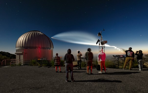 A SpaceX Falcon 9 rocket lights up the sky as seen in this image taken last summer from the U.S. National Science Foundation Kitt Peak National Observatory (KPNO), a Program of NSF NOIRLab, near Tucson, Arizona. Although the rocket lifted off from Vandenberg Space Force Base about 890 kilometers (550 miles) away in California, the recently set Sun lit up the rocket’s exhaust plume for miles as the plume dramatically expanded in Earth’s upper atmosphere.