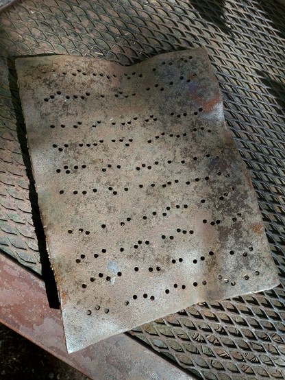the sculpted iron sheet music for the musicians sits on a table, with dots punched in it resembling Braille; I suspect that some specific tune might be coded here, but I've thus far been unable to decipher it