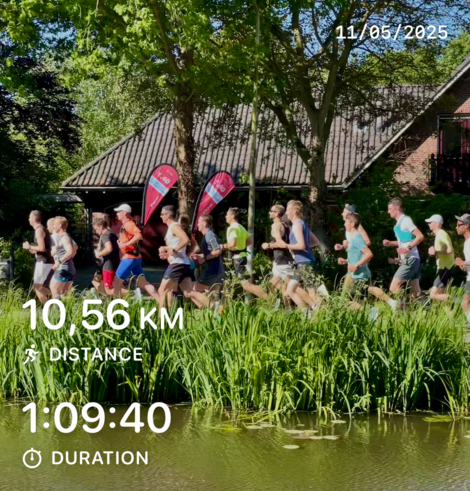 Half marathon runners in a pacer group. On the flags is written 1:40. Displayed on the photo are my running stats: 10,56KM distance and 1:09:40 duration.