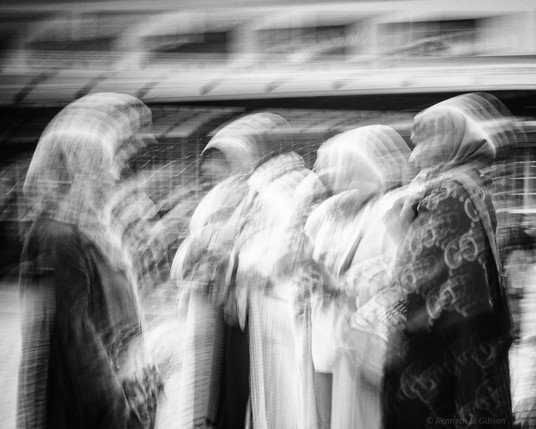 Black and white intentional camera movement photo of women wearing head coverings.