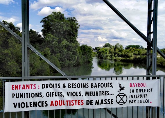 Banderole déployée sur un pont du Gave de Pau : ENFANTS : Droits & besoins bafoués, punitions, gifles, viols, meurtres... Violences adultistes de masse. Bayrou, la gifle est interdite par la loi.
