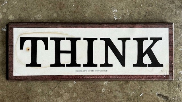 Tame the creative mind! Photograph of a 1960s IBM Corporation wooden wall sign laminated plaque with the word "THINK" in large letters and the phrase "COMPLIMENTS OF IBM CORPORATION" in small letters underneath.