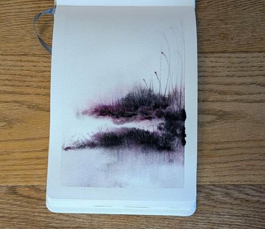 This is a atmospheric watercolor painting in portrait format in an A5 etchrlab sketchbook, using Daniel Smith Lunar Violet and Rose of Ultramarine. A little more than halfway down on the page starting on the right side is an upper landmass contented by a dark swatch tho a second lower thinner and slightly longer landmass.  More Rose of Ultramarine is visible in the to region (that doesn't reach the left side, the bottom one does).  From the bottom landmass dark vertical streaks reach down and granulate at the bottom of the page in more light values. Into the sky the color is very faint only really noticeable due to the white border. Grasses give texture and movement.