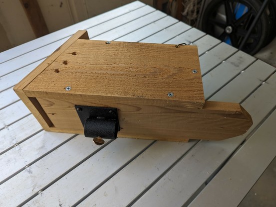 bluebird box with mounting bracket screwed to the back, sitting on folding camp table