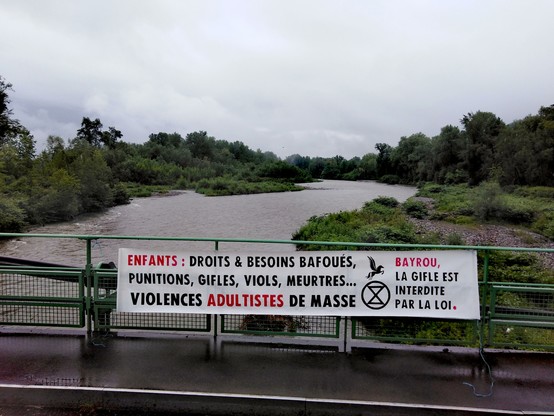 Banderole déployée sur un pont du Gave de Pau : ENFANTS : Droits & besoins bafoués, punitions, gifles, viols, meurtres... Violences adultistes de masse. Bayrou, la gifle est interdite par la loi.
