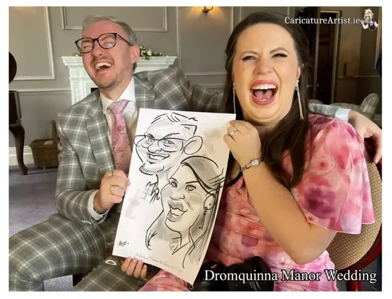 Photo of wedding guest couple laughing and holding a caricature of themselves by Irish Caricature Artist Allan Cavanagh. Dromquinna Manor Kerry Wedding Caricature Artist Entertainment