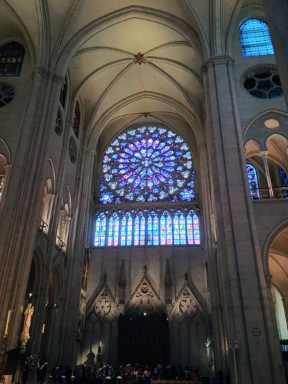 a large stained glass rose window over one of the apses in Notre Dame cathedral in Paris, France.