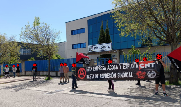 Gewerkschaftskundgebung der CNT-IAA vor dem Unternehmen Foldeco in Madrid mit rot-schwarzen Fahnen und einem Banner