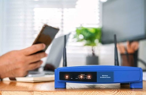 closeup of a wireless router and a man using smartphone on living room at home office