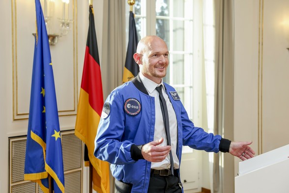 Alexander Gerst in blauer ESA-Jacke spricht vor Rednerpult, im Hintergrund EU-, Deutschland- und Baden-Württemberg-Flagge. © Staatsministerium Baden-Württemberg / Uli Regenscheit