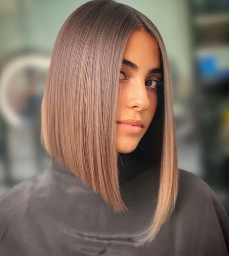 A woman with straight, shoulder-length hair styled in a sleek bob.