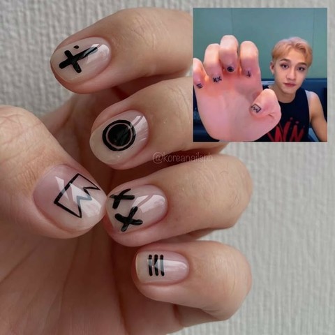 Manicure with simple black shapes on a neutral base, with an inset of Bang Chan showing his own nail art