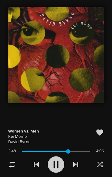 La portada del álbum «Rei Momo» de David Byrne se muestra en reproducción. El arte de la portada presenta una imagen de textura roja, similar a un corazón o una anatomía interna, sobre la que se superponen círculos amarillos y negros. La información de reproducción musical indica que la canción está en pausa, en el minuto 2:48 de una duración total de 4:06.