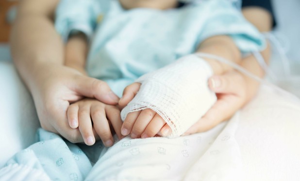 Mother holding child with bandaged arm in hospital setting