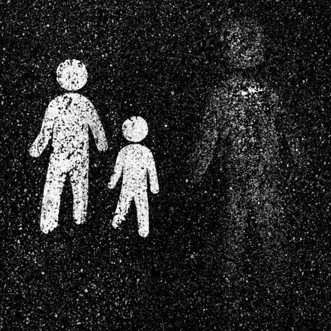 Two weathered white pedestrian symbols on a dark asphalt surface, depicting an adult and a child walking together, with a third faded figure nearby.