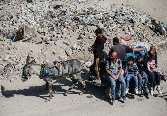 Palestinians make their way with belongings as they fled their homes on a donkey cart, after Israeli air strikes, in the northern Gaza Strip May 16. REUTERS/Mahmoud Issa