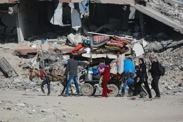 Palestinians transport their belongings by a donkey cart, while the family walks along, as they flee Gaza City on Friday [Bashar Taleb/AFP]